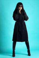 Femme trench et solaire en studio 