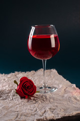 a glass of rose wine with a rose
