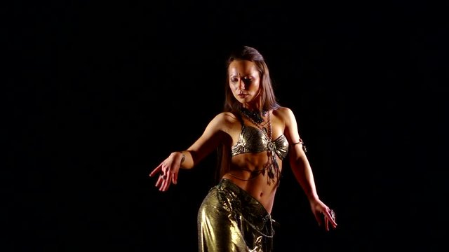 sexy lady is dancing belly dance in black background