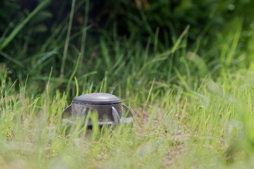 Closeup of an up sprinkler in a green lawn