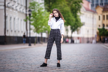 portrait of little beautiful stylish kid girl in city urban street