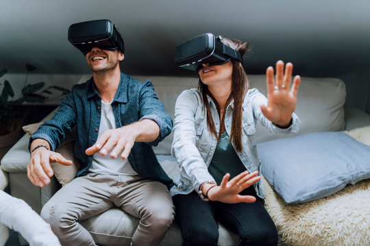 Couple having fun with virtual reality - Woman and a man are using VR glasses at home