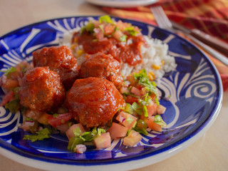 Italian Meatballs with a Local Twist Recipe that includes White Rice Spicy Tomato Sauce and Sliced Tomato Onions and Parsley 