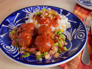 Italian Meatballs with a Local Twist Recipe that includes White Rice Spicy Tomato Sauce and Sliced Tomato Onions and Parsley 