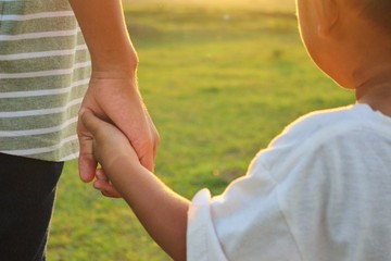 Children walking on the lawn in the evening with bright sky and sunshine, golden yellow evening, blurred photography