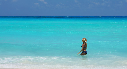 Fototapeta na wymiar Woman swimming in Caribbean sea with a beautiful turquoise color. Vacation in Cancun, Mexico.