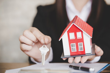 Real estate agent with house model and keys