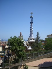 Obraz premium View of the Right Pavilion with a Pinnacle with a five-beam cross of the Park Guell in Barcelona, Spain