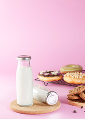bottle of milk and various bakeries on a pink background