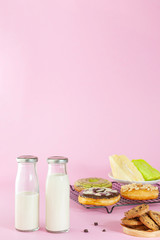 bottle of milk and various bakeries on a pink background