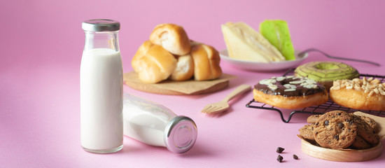 bottle of milk and various bakeries on a pink background