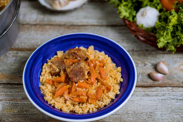 Samarkand pilaf lamb, rice, onion, yellow carrots, vegetable spices on the table in Uzbek national dish.