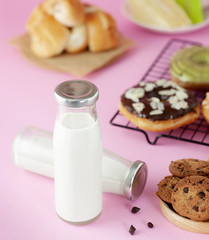 bottle of milk and various bakeries on a pink background
