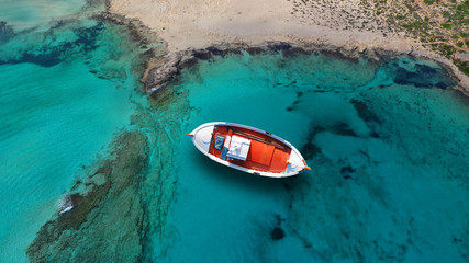 Luftaufnahme von oben Foto des traditionellen Fischerbootes angedockt in der paradiesischen Bucht von Elafonisi mit türkisfarbenem klarem Meer, Insel Kreta, Griechenland