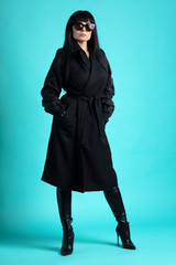 Femme trench et solaire en studio 