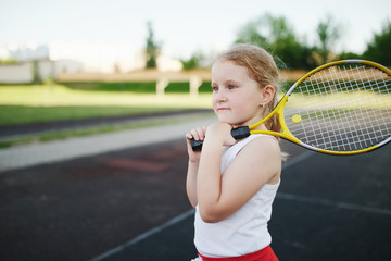 happy girl plays tennis on court outdoors