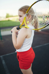 happy girl plays tennis on court outdoors