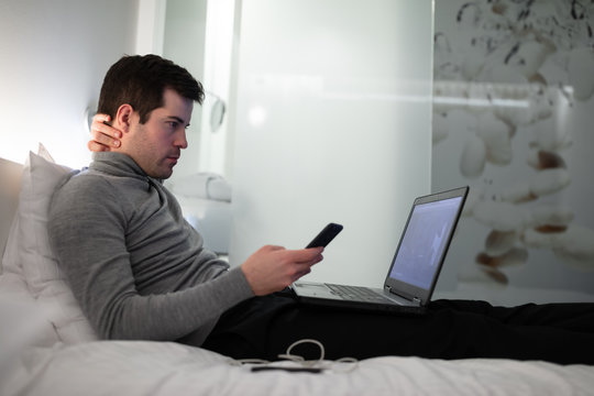 Business man in hotel working on laptop and smartphone