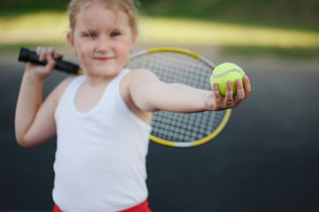 happy girl plays tennis on court outdoors