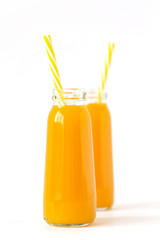 Healthy mango smoothie in a glass with mint and straw isolated on white. Refreshing and tasty smoothies with tropical fruits: mango and banana.