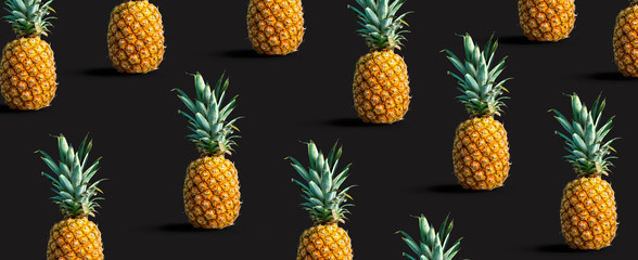 Many pineapples on a solid color background