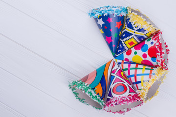 Party hats on white wood table. Beautiful party cone caps with copy space. Happy Birthday composition.