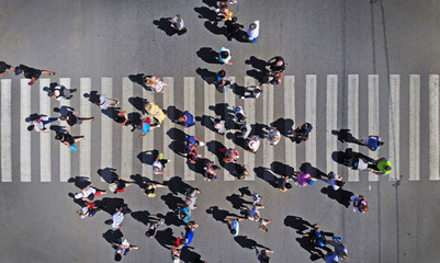 Aerial. People crowd on pedestrian crosswalk. Top view.