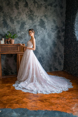 beautiful bride in a long dress by the window