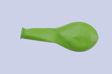 Green deflated balloon. Close up new color balloon isolated on white. Holiday party decoration.