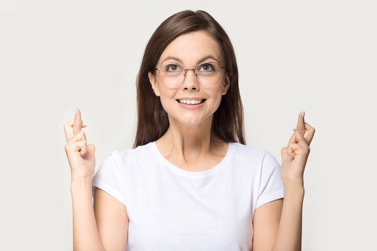 Comical woman in glasses crossing fingers asks for good luck