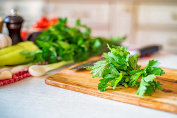 Obraz na płótnie Canvas Fresh green parsley on wooden board in kitchen. Close up salad cooking