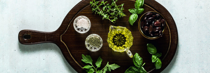 banner of aromatic herbs for cooking and olive oil on a wooden board on the table. ingredients in the kitchen