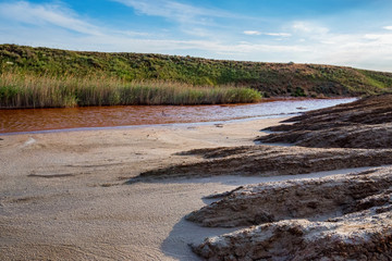 View of small red water river full of iron in beautiful steppe