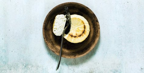 banner of Oven baked ricotta cheese on a clay plate and fork. basic cooking techniques of Italian cuisine. breakfast.