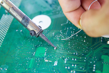 Technicians are using a soldering iron for repairing electronic