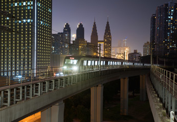 Fototapeta premium At night, the light rail train shuttles through the city.