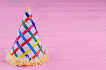Paper cone hat for Birthday celebration. Cardboard party cap on color background with copy space. Birthday greeting card.