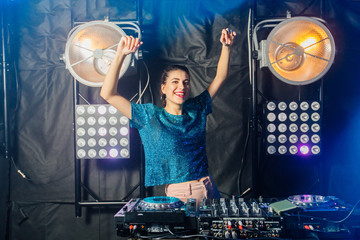 Hispanic dj woman having fun playing music on deck at club nightlife lifestyle. Female dj mixing...