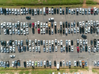 Aerial shot over vehicles at shopping mall parking lot, high angle view looking directly down.