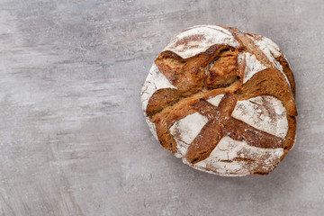 Gold rustic crusty loaves of bread and buns on wooden background. Still life captured from above top view, flat lay.