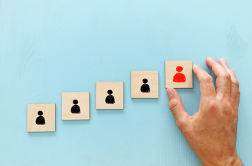 image of wooden blocks with people icon over blue table ,building a strong team, human resources and management concept