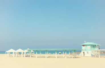 Fototapeta premium Summer vacation and travel holiday concept. Bokeh tropical beach with saver kabin. abstract background. Vintage tone filter