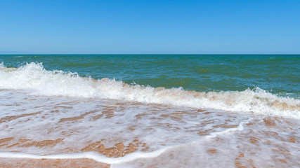 Empty beach with golden sand and azure water