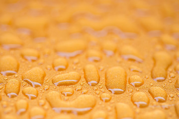 Liquid water drops on an orange background