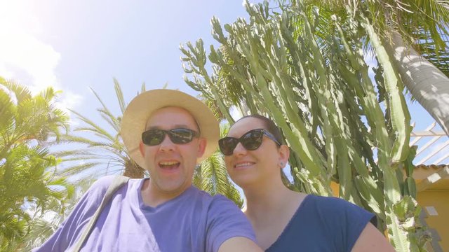 Happy couple taking a selfie and sending greetings in tropical resort in 4k slow motion  60fps