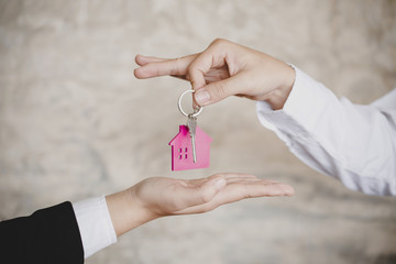 Real estate broker giving customer key from new flat
