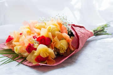 Bouquet of yellow and red roses on a white surface. Front view - Powered by Adobe