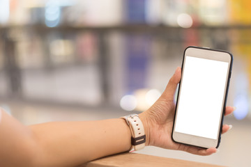 Focusing hand is holding the phone up and the background is blurred.