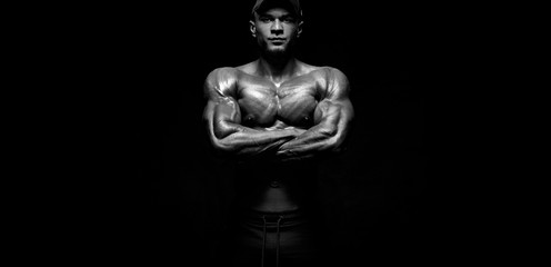 Fototapeta na wymiar Bodybuilding competitions on the scene. Man sportsmen bodybuilder physique and athlete. Fitness motivation. Black and white photo.