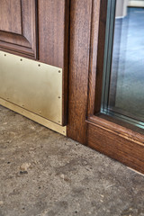 Solid wood entrance door with solid brass kick plates. Entrance door with sidelight. Wood door manufacturing process.